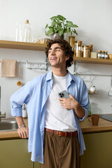 Handsome young man with curly hair enjoying a relaxed moment at home