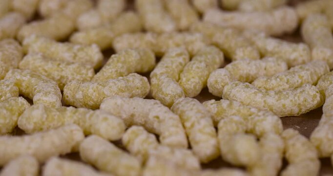 yellow large sweet sticks of corn flour with added sugar for quick cooking with milk or yogurt, ready-to-eat corn sticks scattered on paper