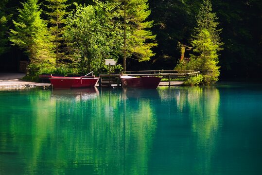 View across Blausee of Boats moored along the waterfront, Kandersteg, Bernese Oberland, Switzerland