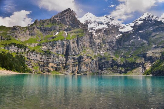 View of snowcapped mountains and Oeschinen Lake (Oeschinensee) in the Bernese Oberland near Kandersteg, Switzerland