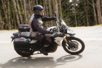 Fototapeta premium Motorradfahrer auf einer Landstrasse in einer Kurve beim dynamischen fahren