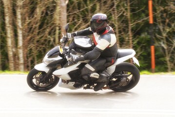 Motorradfahrer auf einer Landstrasse in einer Kurve beim dynamischen fahren