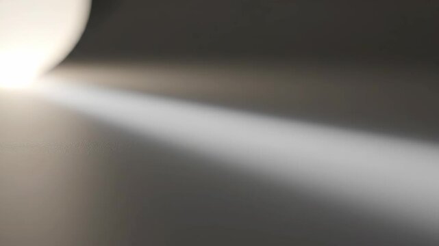 A dramatic spotlight cuts across a dark, textured surface, creating a striking contrast and highlighting a path of light