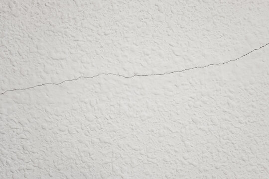 White textured wall having a horizontal crack line