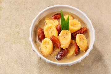 Kolak kurma, traditional Indonesian sweet dessert made with dates cooked in coconut milk, palm...