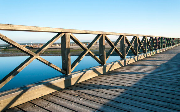 Ponte di legno attraversante la bassa marea in una soleggiata giornata invernale 