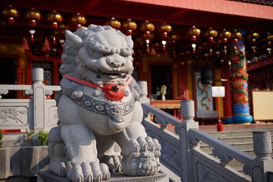 Traditional Chinese stone guardian lion Foo Dog statue at a temple entrance