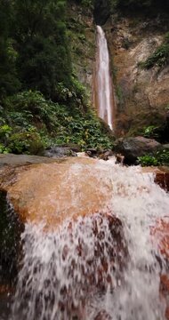 Salto do Prego waterfall in a lush green forest.
