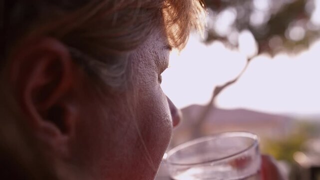 Adult Woman Drinking Refreshing Cocktail on Balcony at Sunset