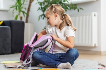 Little Girl Packing Backpack at Home. Back to school © Olha Tsiplyar