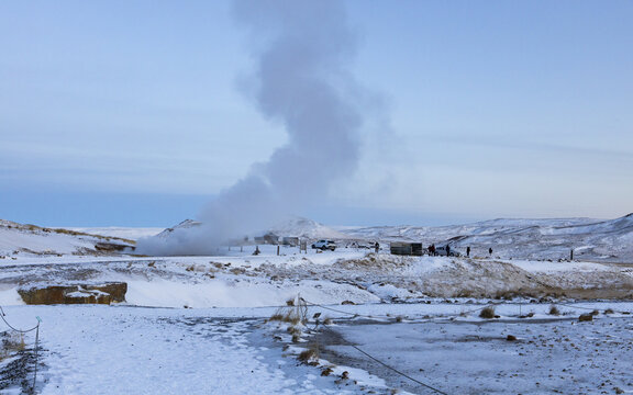 View of geothermal steam billowing above the snowy landscape, contrasting with the cold sky, in Seltun Geothermal Area, Hafnarfjardarkaupstadur, Iceland.