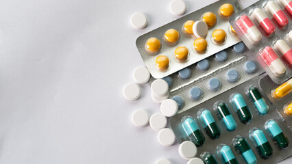 Colorful medicine pills and capsules on white background, pharmaceutical healthcare concept with antibiotics, prescription drugs and medical treatment copy space.