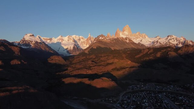Aerial sunset view of Mount Fitz Roy from El Chalten. Golden rays illuminating Patagonian mountains