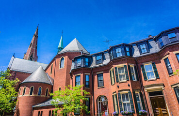 Obraz premium A row of brick buildings with a church in the background