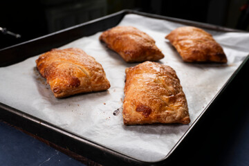 Close up of freshly baked golden crispy danish pastries with apricot filling