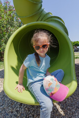 Girl having fun in tube slide on playground