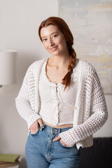 Young woman with red hair enjoying a cozy moment in her modern apartment