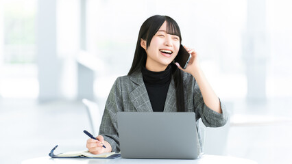 スマートフォンで通話しながら笑う女性ビジネスパーソン, Businesswoman smiling while talking on smartphone © Trickster*