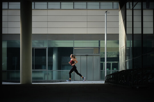 side view of Woman doing daily running in urban barcelona