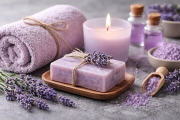 A serene still life featuring lavender-scented bath products including a soap bar, bath salts, essential oils, a fluffy towel, and a lit candle. Focuses on relaxation and self-care.