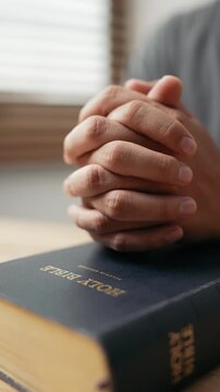 Hands clasped prayer with Holy Bible for Christian faith, spirituality, worship, devotion, hope, and religious belief, prayer time in church, trust in God, and spiritual guidance.