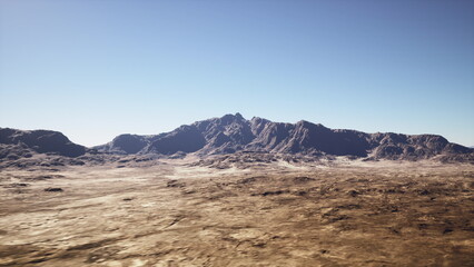 Naklejka premium arid desert plain with rugged mountains under clear blue sky, cracked earth foreground, sparse scrub and rocky ridgeline, warm midday light, cinematic wide shot