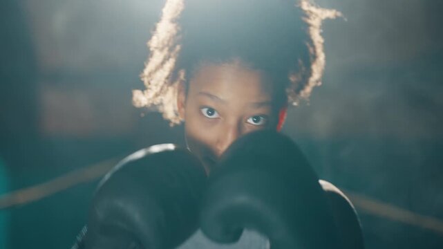 Black woman fighting, portrait of active sportswoman striking by arm to camera. Professional sport and fitness for stay healthy and slender, combat sports and self-defense class for ladies, be strong
