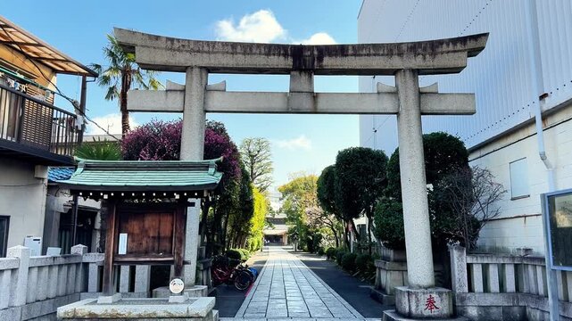 Traditional stone torii opening onto a quiet shrine path