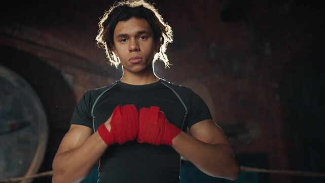 Self-confident fighter looking at camera and showing forward by index finger. Call rival to fight and challenge, do sport and be powerful, african american young man in gym, strong look, champion