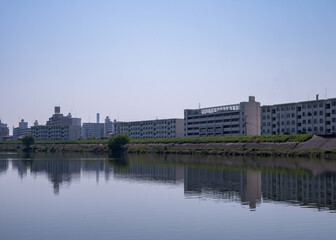 川面に映る集合住宅と青空の風景