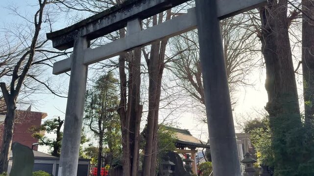 Large stone torii gate silhouetted by afternoon sunlight