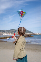 Rear view of a girl flying a kite at the beach