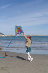 Girl flying kite on beach