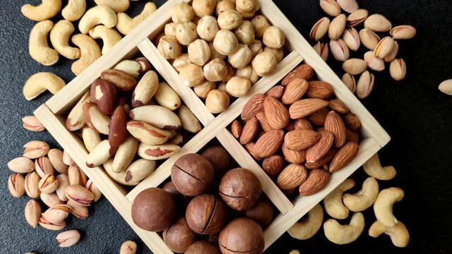 Wooden box with macadamia nuts, almonds, pistachios, and hazelnuts as ingredients for healthy eating. Nuts as a food background for your design