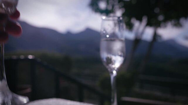 Elegant Scene with Two Glasses of Chilled Champagne on Veranda Facing Mountains Under Clear Sky