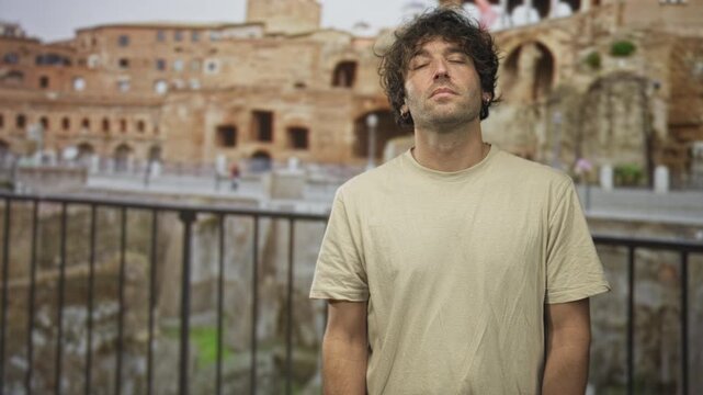 Man pointing finger upward with bare forearm visible at building ruins; contemplation travel nostalgia.