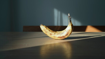 木目のテーブルに置かれたバナナ 差し込む自然光とドラマチックな影 静物 / Ripe bananas on wooden table with dramatic natural light and long shadows, still life