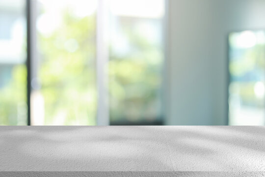 abstract blurred garden view form living room window with modern plain concrete table counter background for show , promote ,design banner ads on display concept