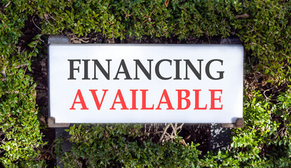 Financing available symbol. Concept words Financing available on beautiful big white sign plate. Beautiful green garden background. Business financing available concept. Copy space.