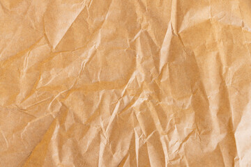Fototapeta premium Crumpled Brown Kraft Paper Texture Background,High-angle close-up of wrinkled and creased brown kraft paper surface. This rustic, recycled paper texture is ideal for organic branding, vintage,