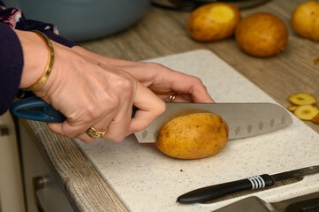Slicing Potatoes for Roasting on a Kitchen Board