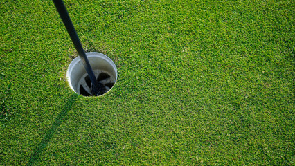 Obraz premium Golf hole is on a green lawn in a beautiful golf course.