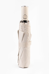 Folded biege automatic umbrella isolated on white background