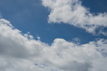 Obraz premium White and grey clouds scattered across a bright blue sky