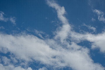 Fototapeta premium Wispy white clouds stretching diagonally across a blue sky