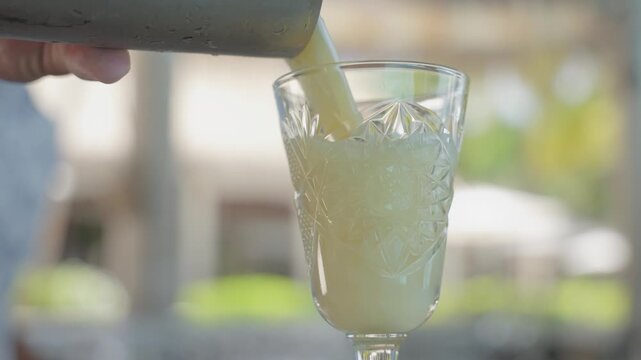 Creamy yellow drink poured into cut-glass goblet