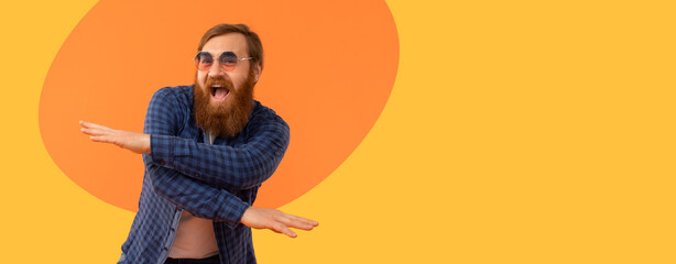 A man is dancing joyfully against a bright orange background. He wears sunglasses and a blue...