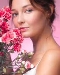 Naklejka premium Romantic Beauty Portrait of a Woman with Pink Carnations