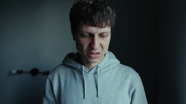 Angry man slapping his face in daylight room, self directed anger, emotional breakdown, inner conflict and psychological frustration