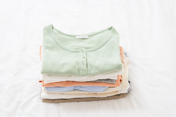 Fototapeta premium Clothes stacked on a bedroom bed